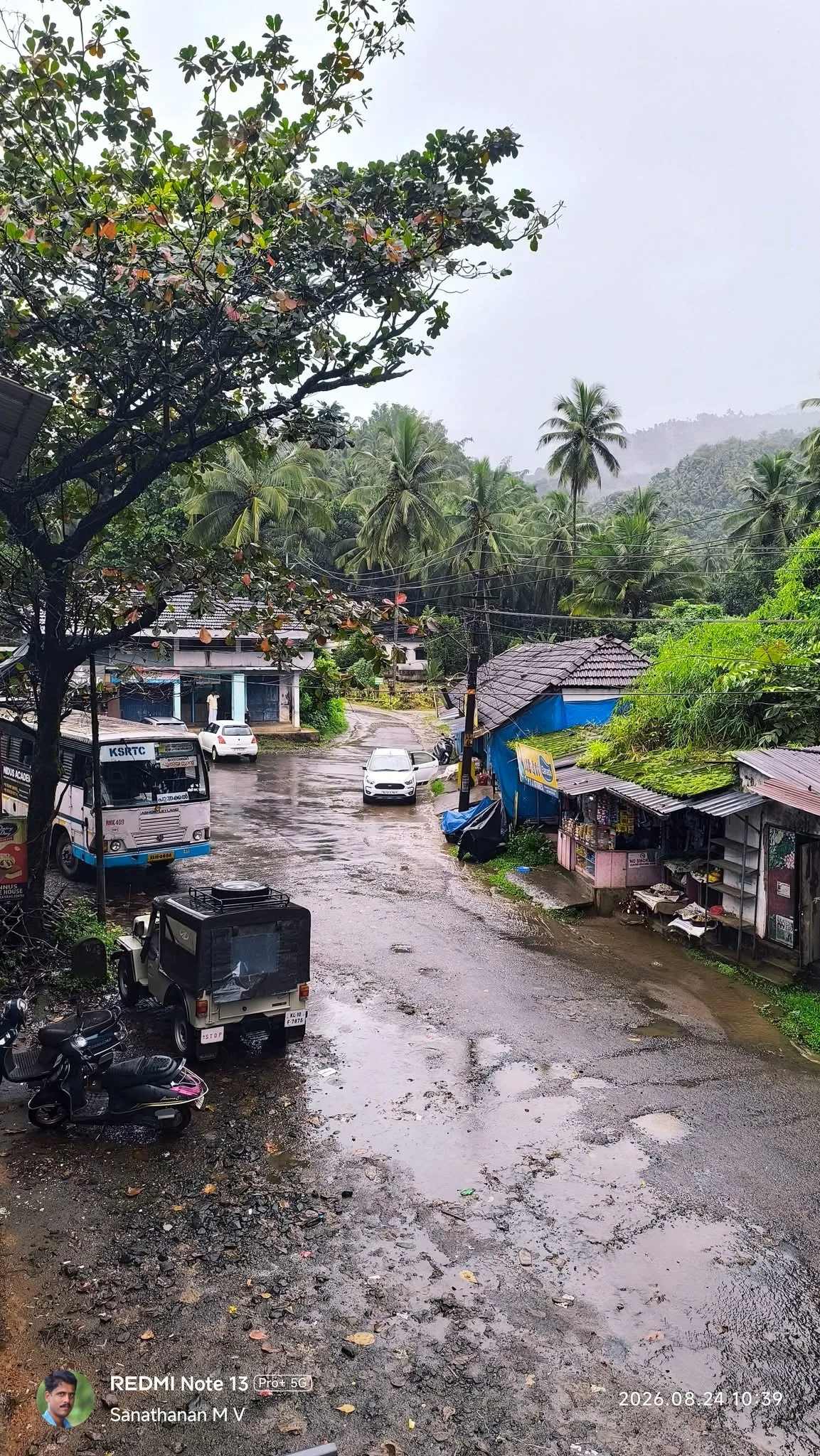 Rainy Aanakkampoyil junction with KSRTC bus and coconut trees